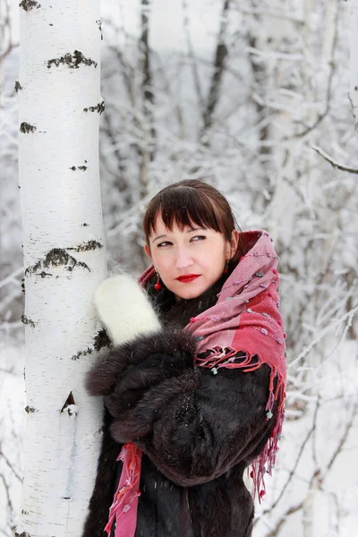 Flickan i vinter skog ser bort — Stockfoto