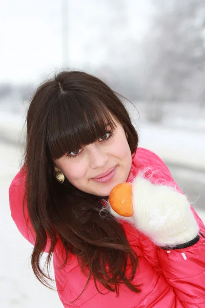 Beautiful girl with mandarin in hand — Stock Photo, Image
