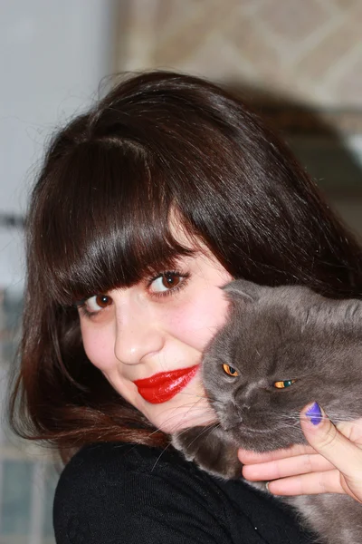 Ein junges Mädchen mit einer Katze in der Hand — Stockfoto
