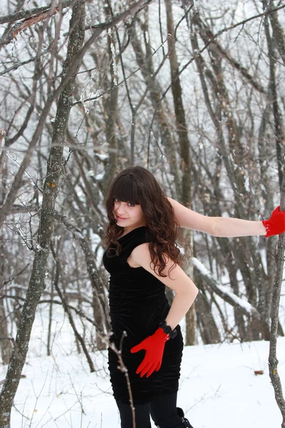 Chica en el bosque de invierno en un vestido negro — Foto de Stock