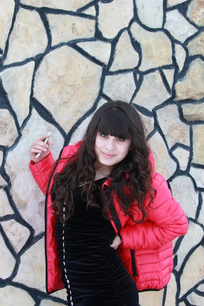 A girl in a black dress near a stone wall — Stock Photo, Image