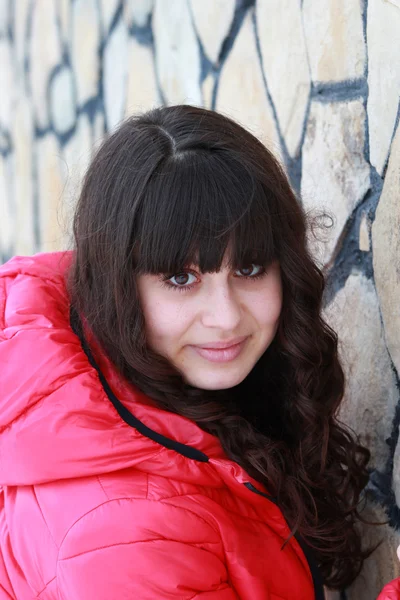 Retrato de una joven mujer cerca de un muro de piedra —  Fotos de Stock