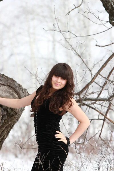 Una chica sonriente en un vestido negro — Foto de Stock