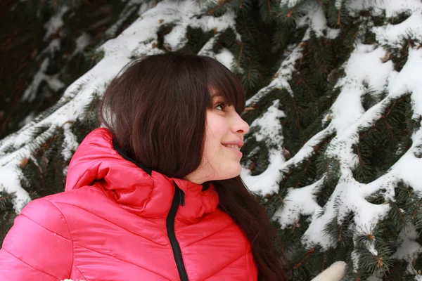 Счастливая девушка в пиджаке рядом с елкой — стоковое фото