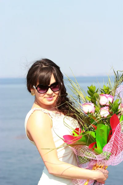 Une belle fille avec un bouquet de roses sur un fond de Volg — Photo