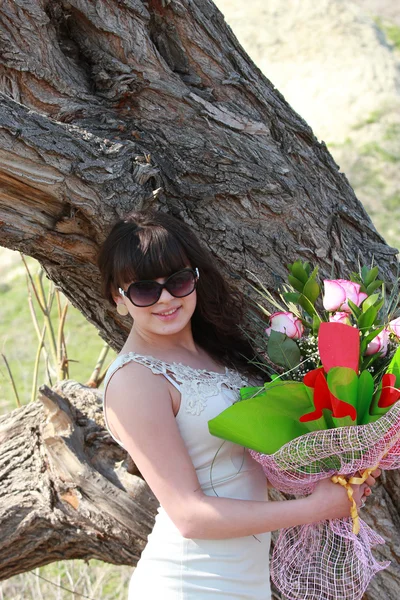 The girl with a bouquet of roses near the old oak — Stock Photo, Image