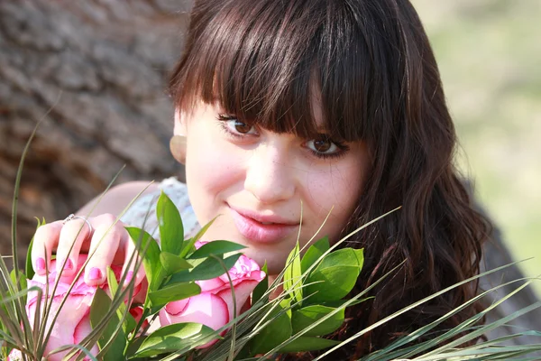 バラの花束を持つ美しい少女の肖像画 — ストック写真