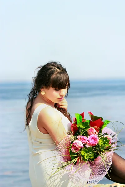 Young brunette with a bouquet of roses — Stock Photo, Image