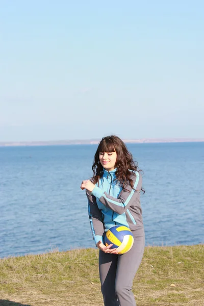 Une jeune femme brune en survêtement jouant au ballon — Photo
