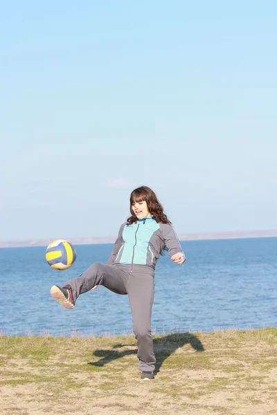 Flicka i sport kostym spelar med en boll — Stockfoto