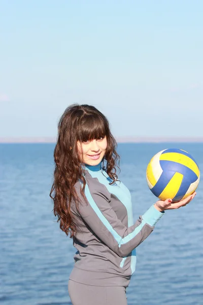 Молодая брюнетка держит волейбол — стоковое фото