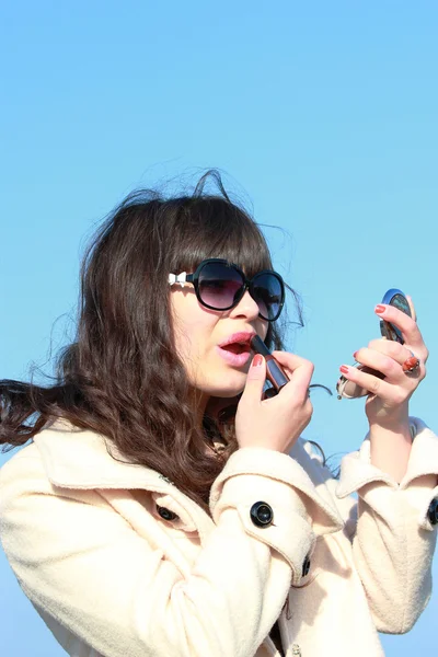 Una joven pinta los labios con lápiz labial —  Fotos de Stock