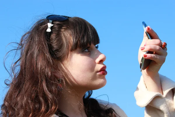 A young brunette woman looking at herself in the mirror — Stock Photo, Image