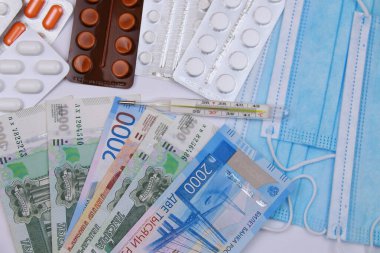 Koronavirüs enfeksiyonuyla mücadele sırasında yüksek sıcaklık kavramı. Tıbbi maske, Rus parasına karşı haplar.