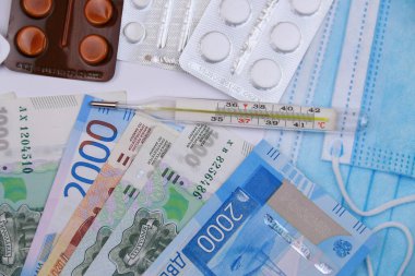 Koronavirüs enfeksiyonuyla mücadele sırasında yüksek sıcaklık kavramı. Koronavirüse karşı Rus parasının arka planına karşı koruyucu araçlar