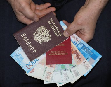 Erkeklerin elinde, emeklilik sertifikası, pasaport ve Rus parası.
