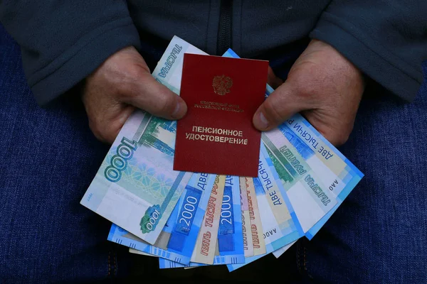 Emeklilik ödemeleri. Emeklilik belgesi ve para erkeklerin elinde.