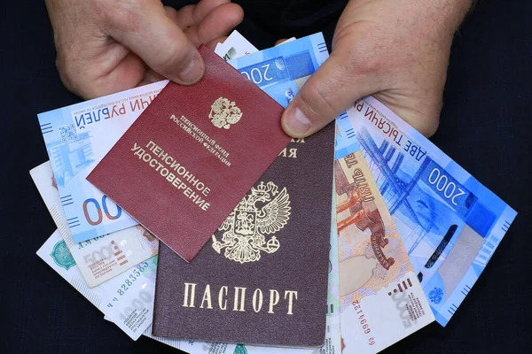 Emeklilik belgesi, Rus pasaportu ve erkeklerin elindeki para.