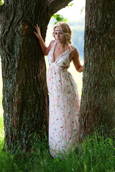 Kaunis tyttö puun lähellä — kuvapankkivalokuva