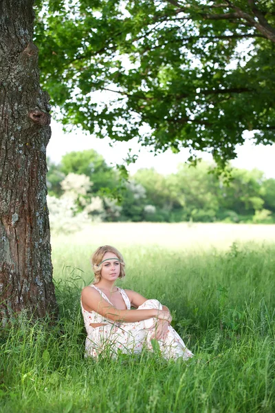 En flicka sitter i ett träd — Stockfoto