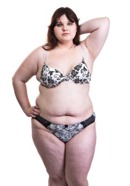 Beyaz bir arka plan üzerinde ayakta kalın genç kız. 