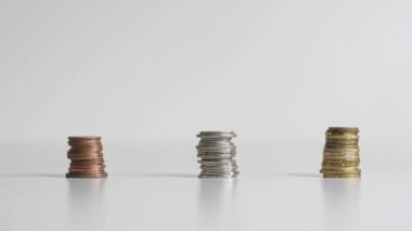 Tarafsız bir arkaplanda yükselen ve düşen üç bakır, gümüş ve altın para yığını. Finansal piramit durdurma videosu. Yüksek kalite 4k görüntü