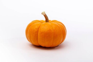 Beyaz arka planda izole edilmiş turuncu balkabağı. Balkabakları ticari kullanım ve gıda, estetik ve eğlence amaçlı olarak yaygın olarak yetiştirilir. Şükran Günü ve Cadılar Bayramı süslemelerinde çok tüketilir.