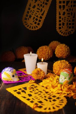 Mumlu şekerkafalar, Cempasuchil çiçekleri ya da Marigold ve Papel Picado. Geleneksel olarak Meksika 'da ölenlerin bayramını kutlamak için sunaklarda kullanılan dekorasyon.