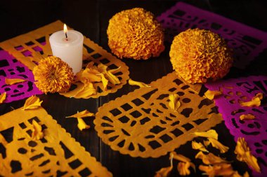 Cempasuchil portakal çiçekli mum veya Marigold. (Tagetes erecta) ve Papel Picado. Geleneksel olarak Meksika 'da ölenlerin bayramını kutlamak için sunaklarda kullanılan dekorasyon.