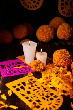 Cempasuchil portakal çiçekli mumlar ya da Marigold. (Tagetes erecta) ve Papel Picado. Geleneksel olarak Meksika 'da ölenlerin bayramını kutlamak için sunaklarda kullanılan dekorasyon.
