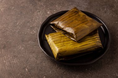 Prehispanic dish typical of Mexico and some Latin American countries. Corn dough wrapped in banana leaves. The tamales are steamed. 