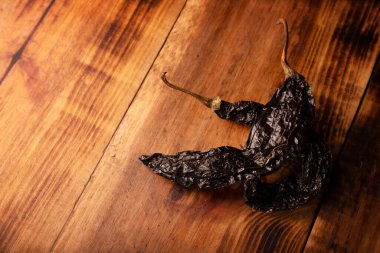 Şili Pasillası. Ayrıca Şili zencisi ya da Şili prieto olarak da bilinir. Bu Meksika biberi kurutulmuş chilaca biberidir ve çeşitli Meksika hazırlıklarında kullanılır..