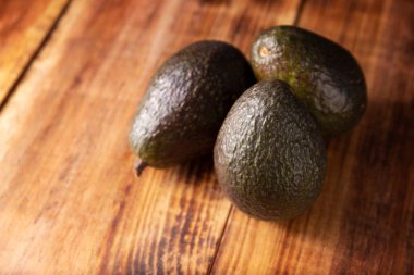 Meksika avokadosu (persea americana) rustik ahşap masada. Guacamole hazırlamak için ana malzeme. Resmi kopyalama alanı ile kapat.