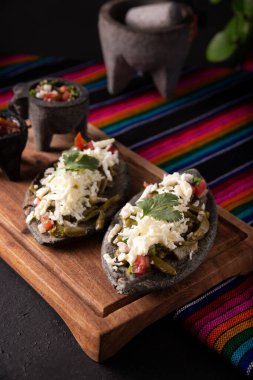 Nopales 'li ev yapımı Tlacoyos. Meksika öncesi İspanyol yemeği. Mavi mısır unlu börek. İçi yeniden kızartılmış fasulye dolu. Meksika 'da popüler sokak yemekleri.
