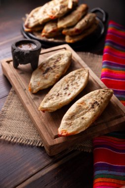 Tlacoyos. Meksika 'da mısır unlu börekten yapılmış İspanyol yemeği Chicharron Prensado (ezilmiş domuz derisi) ile doludur. Meksika 'da popüler sokak yemekleri. 