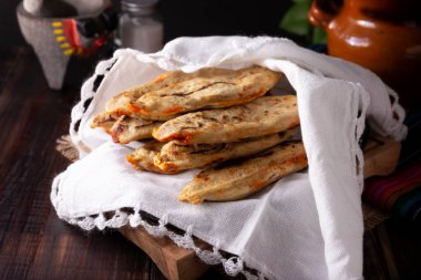 Tlacoyos. Meksika 'da mısır unlu börekten yapılmış İspanyol yemeği Chicharron Prensado (ezilmiş domuz derisi) ile doludur. Meksika 'da popüler sokak yemekleri. 