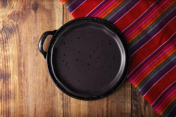 墨西哥厨房用具 色彩艳丽的传统面料 空的黑色盘子放在木制的乡村餐桌上 Flatlay — 图库照片