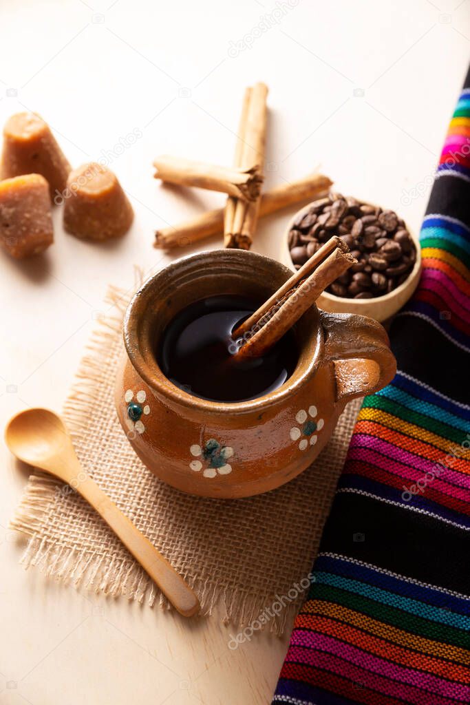 Cafe de Olla. Traditional Mexican coffee and basic ingredients for its preparation, coffee, cinnamon and piloncillo, served in a clay cup called 