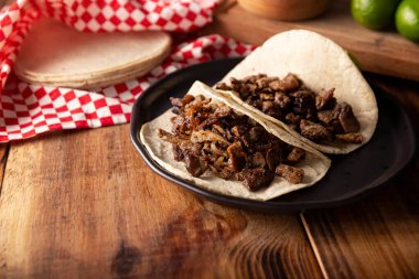 Tacos de Bistec. Homemade grilled meat in a corn tortilla. Street food from Mexico, traditionally accompanied with cilantro, onion and spicy sauce or guacamole
