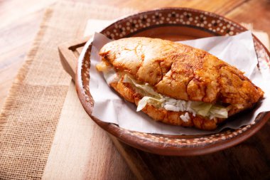 Pambazo. Sandwich marinated in sauce and roasted on a comal traditionally stuffed with potatoes and chorizo, a classic of Mexican street food.