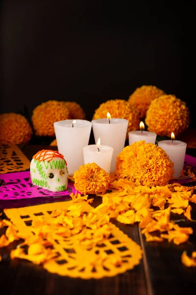 Sugar skulls with Candle, Cempasuchil flowers or Marigold and Papel Picado. Decoration traditionally used in altars for the celebration of the day of the dead in Mexico