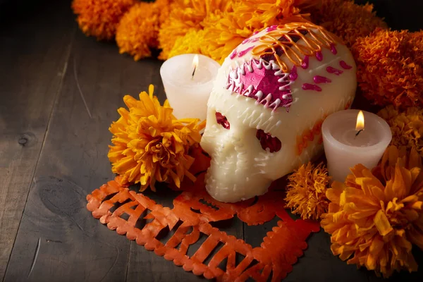 Sugar skulls with Candle, Cempasuchil flowers or Marigold and Papel Picado. Decoration traditionally used in altars for the celebration of the day of the dead in Mexico