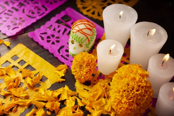 Candle, Cempasuchil çiçekleri ya da Marigold ve Papel Picado 'lu şekerkafalar. Geleneksel olarak Meksika 'da ölenlerin bayramını kutlamak için sunaklarda kullanılan dekorasyon.