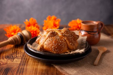 Pan de Muerto. Ölü sezonunda tüketilen susam tohumlu tipik Meksika tatlı ekmeği. Sunaklarda ve sunaklarda temel bir unsurdur.