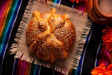 Pan de Muerto. Ölü sezonunda tüketilen susam tohumlu tipik Meksika tatlı ekmeği. Sunaklarda ve sunaklarda temel bir unsurdur.