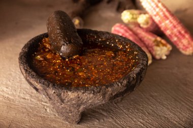 Molcajete with chile de arbol sauce. Traditional mexican version of mortar and pestle handmade of volcanic stone. Essential element in the preparation of the authentic Mexican sauce clipart
