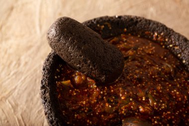 Molcajete with chile de arbol sauce. Traditional mexican version of mortar and pestle handmade of volcanic stone. Essential element in the preparation of the authentic Mexican sauce clipart