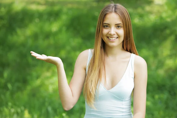 Uśmiechnięta młoda kobieta wskazując na miejsce — Zdjęcie stockowe