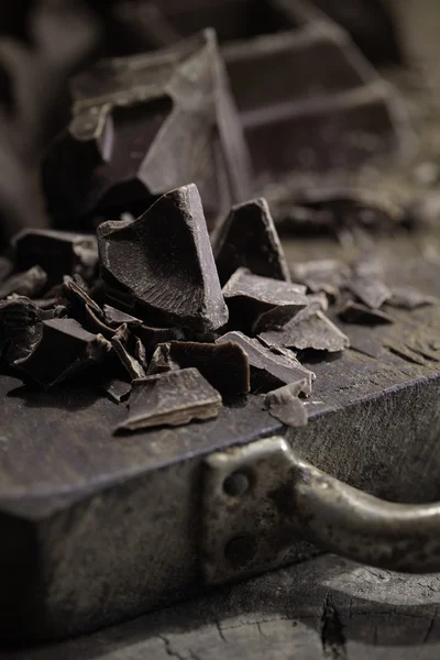 Stukken van donkere chocolade op een houten achtergrond — Stockfoto