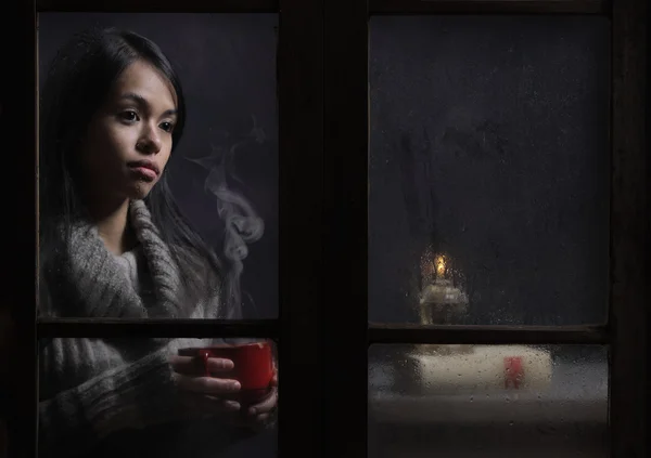 커피 또는 차 한 잔 함께 젖어 창 뒤에 여자 — 스톡 사진